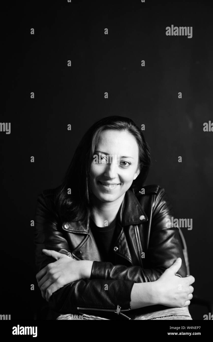 Studio Portrait einer attraktiven jungen Frau in schwarzem Leder Jacke gegen einen einfachen Hintergrund Stockfoto