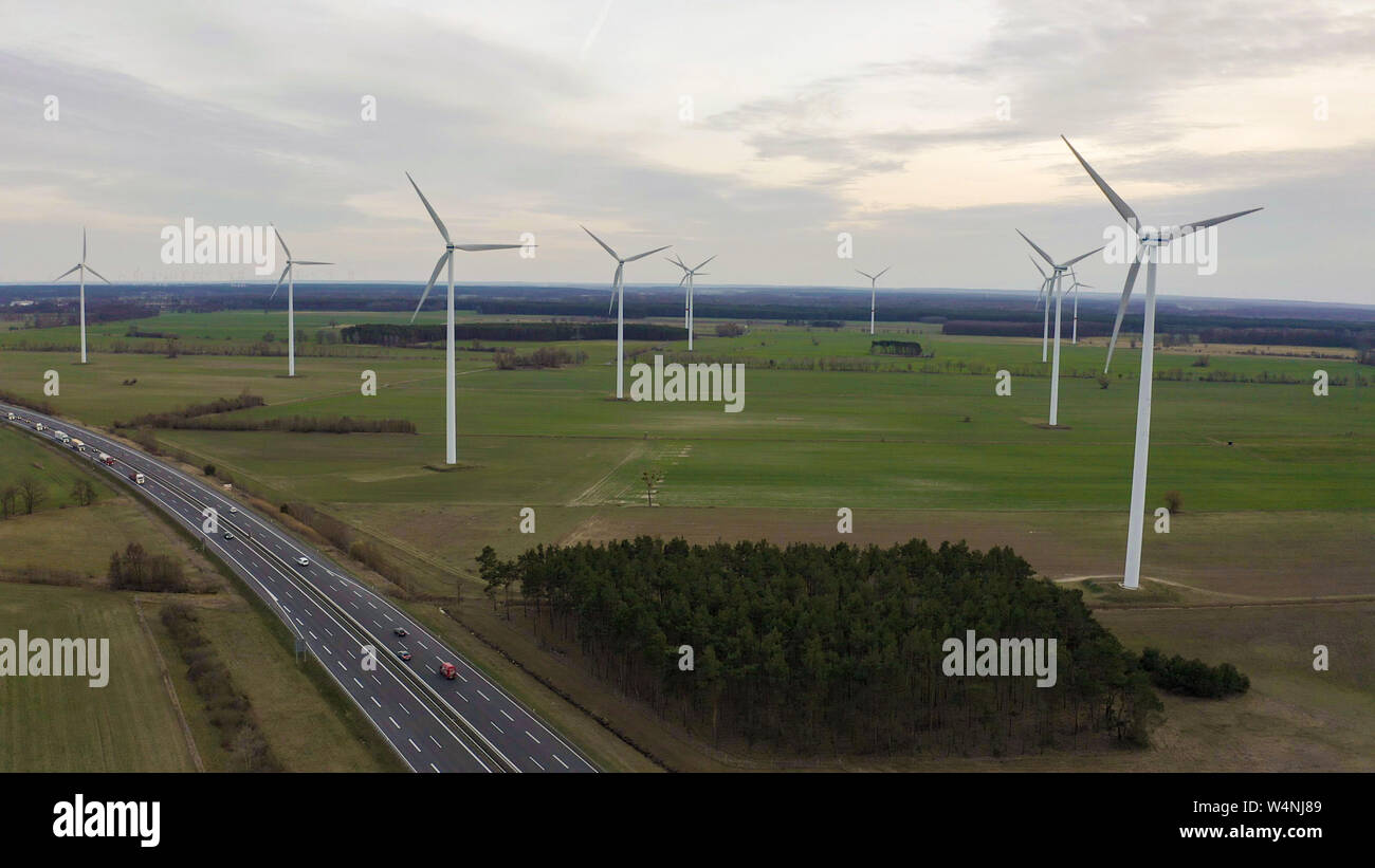 Windenergieanlagen und landwirtschaftliche Felder an einem Sommertag - Energieerzeugung mit sauberer und erneuerbarer Energien - Luftaufnahme Stockfoto