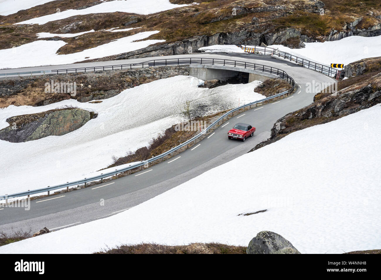 Einzelne rote Auto auf der windigen Straße von Geiranger zum Dalsnibba, Moere og Romsdal, Norwegen Stockfoto