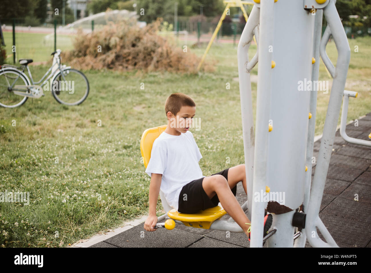 7 Jahre altes Kind ist die Ausbildung bis auf der horizontalen Leiste zu ziehen. Emotionen auf dem Gesicht eines Kindes aus schwierigen sportlichen Übungen. Gesunder Lebensstil Stockfoto