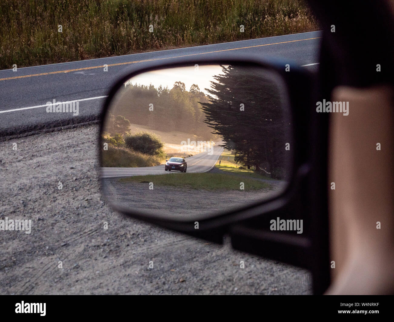 Auto entlang der Straße fahren im Spiegel auf der Fahrerseite Stockfoto