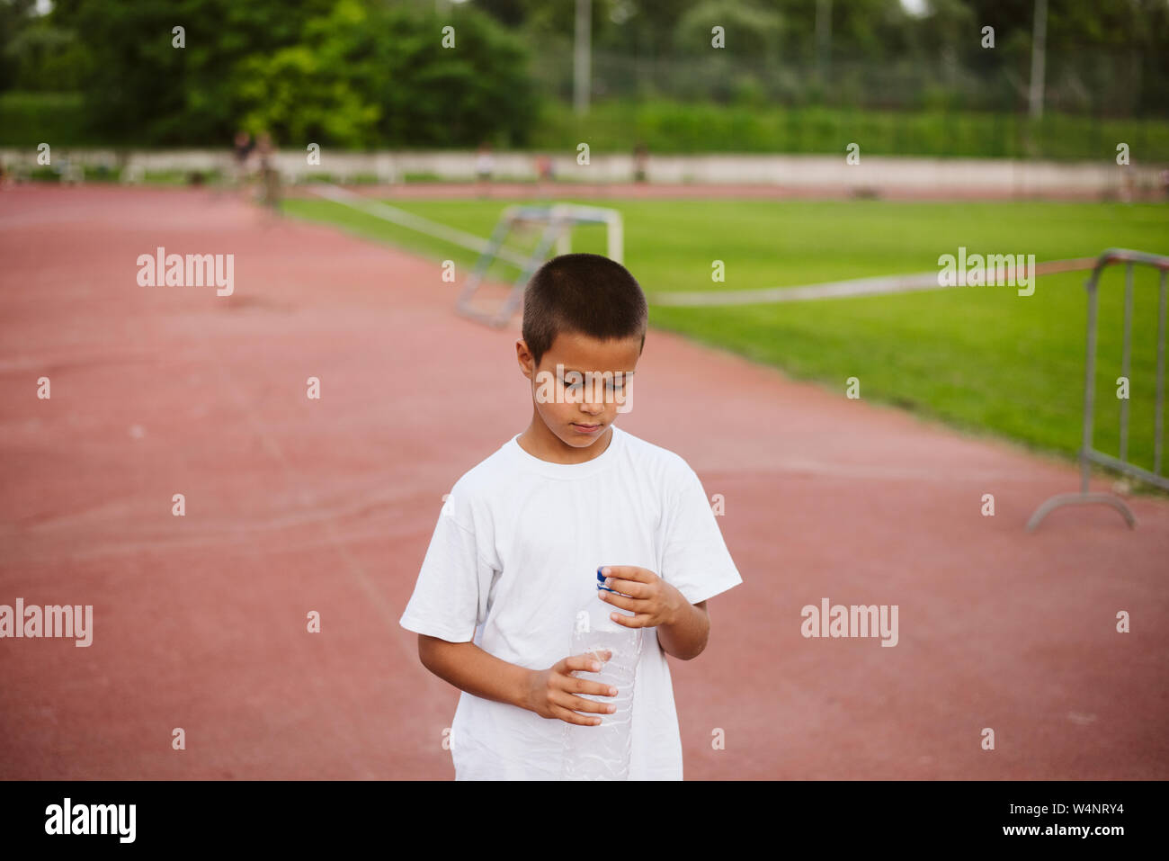 7 Jahre altes Kind ist die Ausbildung bis auf der horizontalen Leiste zu ziehen. Emotionen auf dem Gesicht eines Kindes aus schwierigen sportlichen Übungen. Gesunder Lebensstil Stockfoto