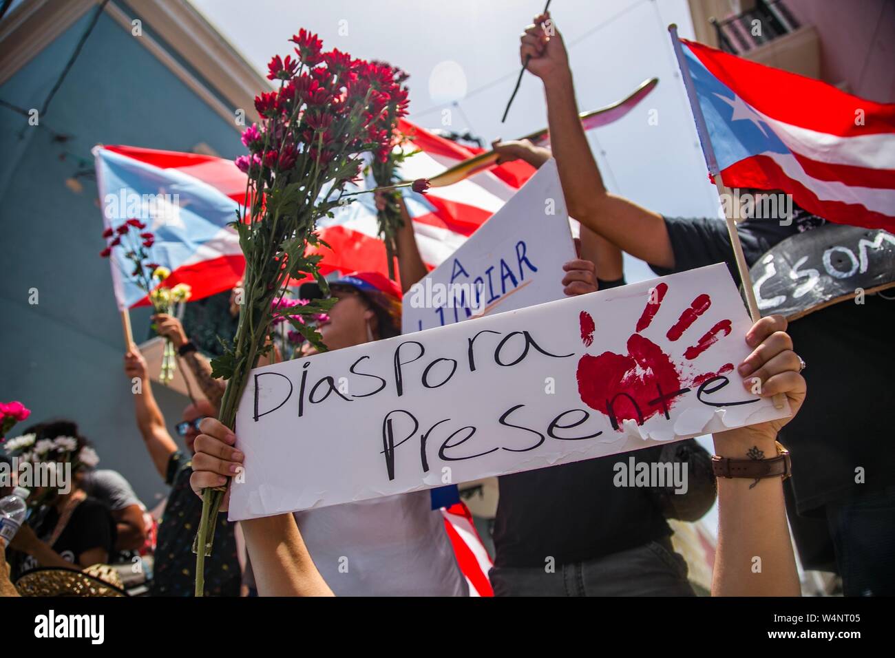 24 Juli 2019, Puerto Rico, San Juan: "Der diaspora Es gibt", sagt ein Demonstrator im Ausland leben in einem Protest vor der Residenz des Gouverneurs Rossello, auch bekannt als La Fortaleza. Die Proteste von einem Korruptionsskandal in der Regierung und die Veröffentlichung von Nachrichten in einer Chat Group, in denen ausgelöst wurden, entsprechend viele, einige Bemerkungen waren feindselig gegenüber Frauen und Homosexuellen und respektlos der zahlreichen Opfer des Hurrikan Maria von 2017. Puerto Rico's Kopf der Regierung, Rossello, ist immer noch im Amt, im Gegensatz zu den anhaltenden Spekulationen über seinen Rücktritt. Foto: Marcos Caballero/dpa Stockfoto