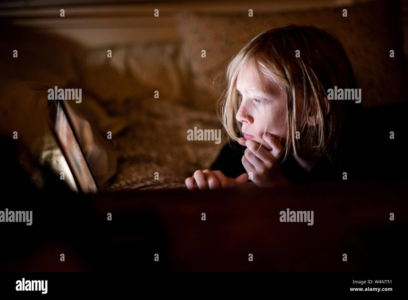 Kind auf dem Bildschirm in der Dunkelheit Stockfoto