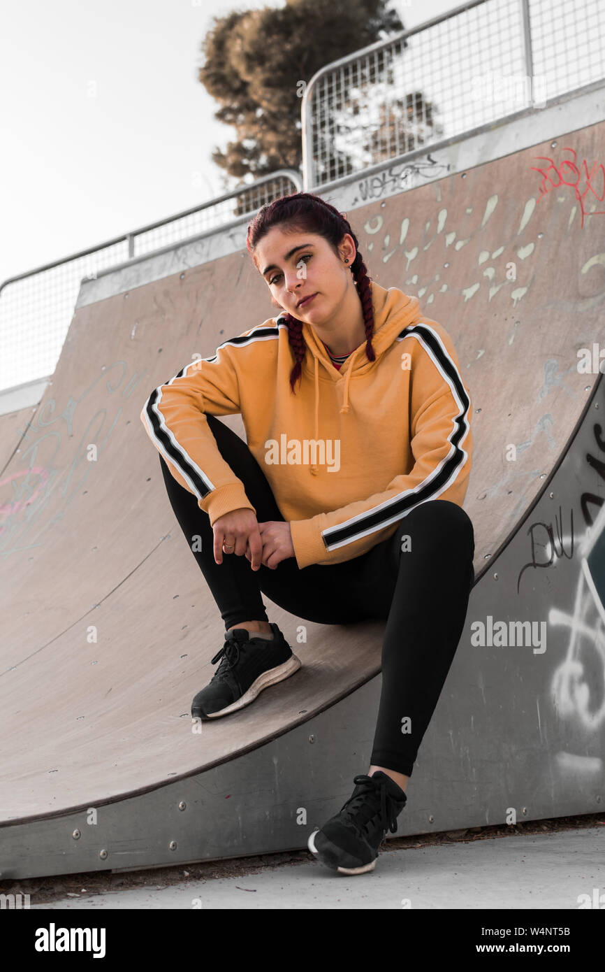 Junge Frau mit der Straße Kleidung auf einer Eisbahn. Lifestyle Konzept, Skate. Stockfoto