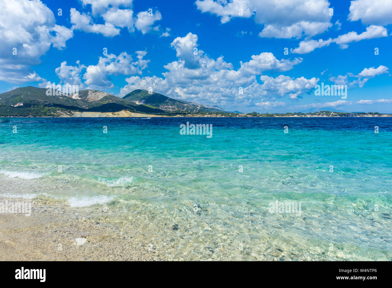 Griechenland, Zakynthos, weissen Sandstrand mit azurblauem Wasser und gebirgige Insel hinter Stockfoto