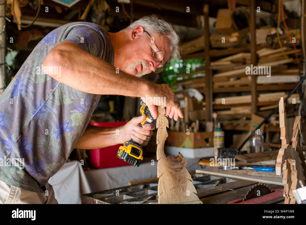 Ein Handwerker lehnt sich über seine Arbeit zu bohren Stockfoto