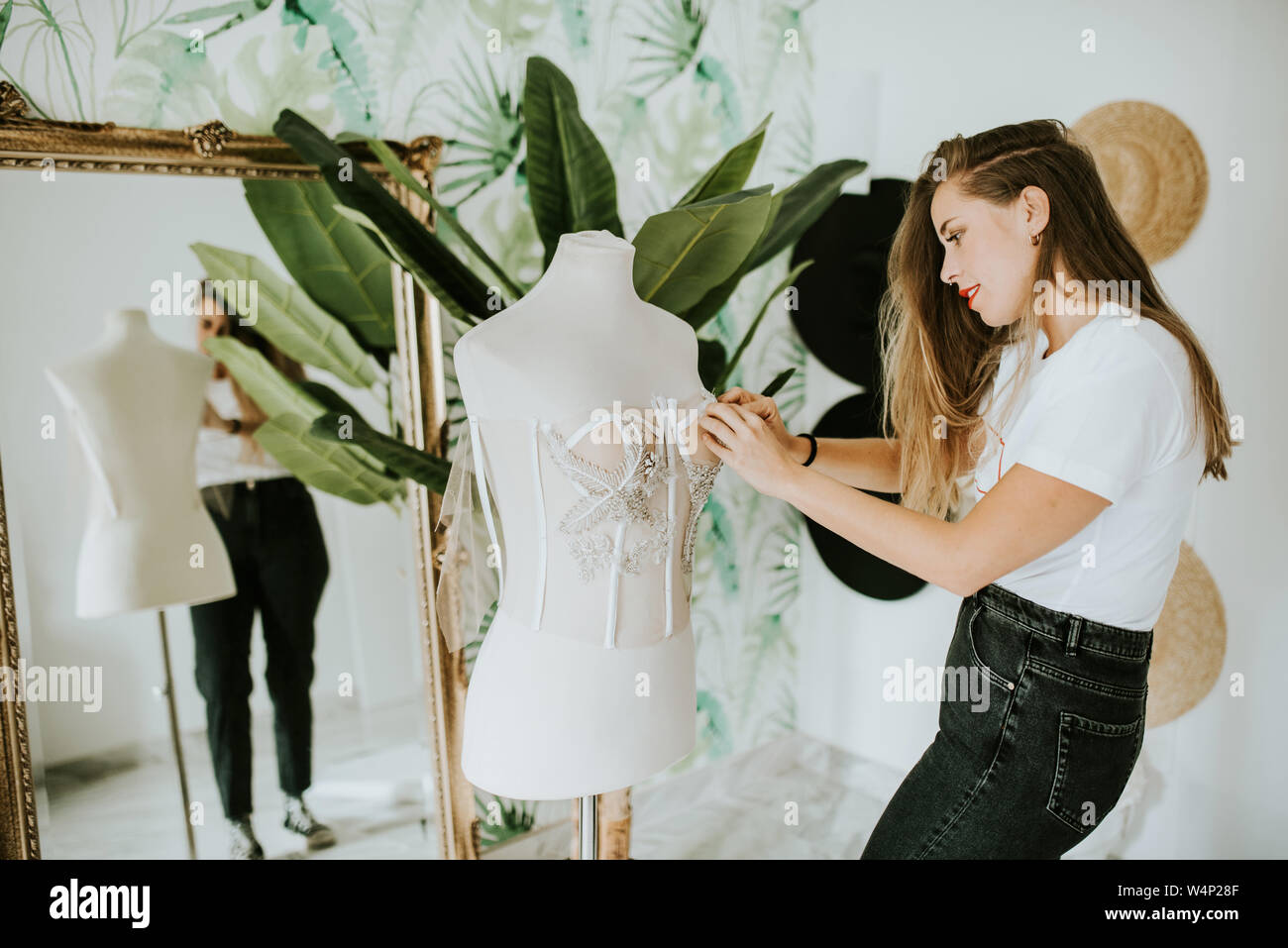 Fashion Designer, eine Hochzeit Kleid vor einem Spiegel Stockfoto
