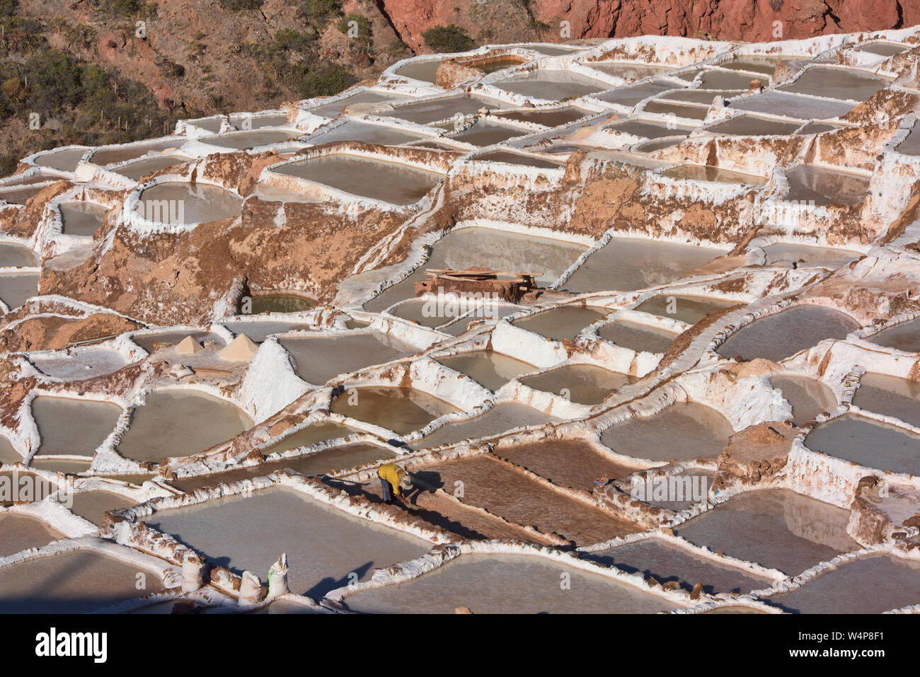 Arbeitnehmer durch die Salinen von Maras, das Heilige Tal, Peru umgeben Stockfoto