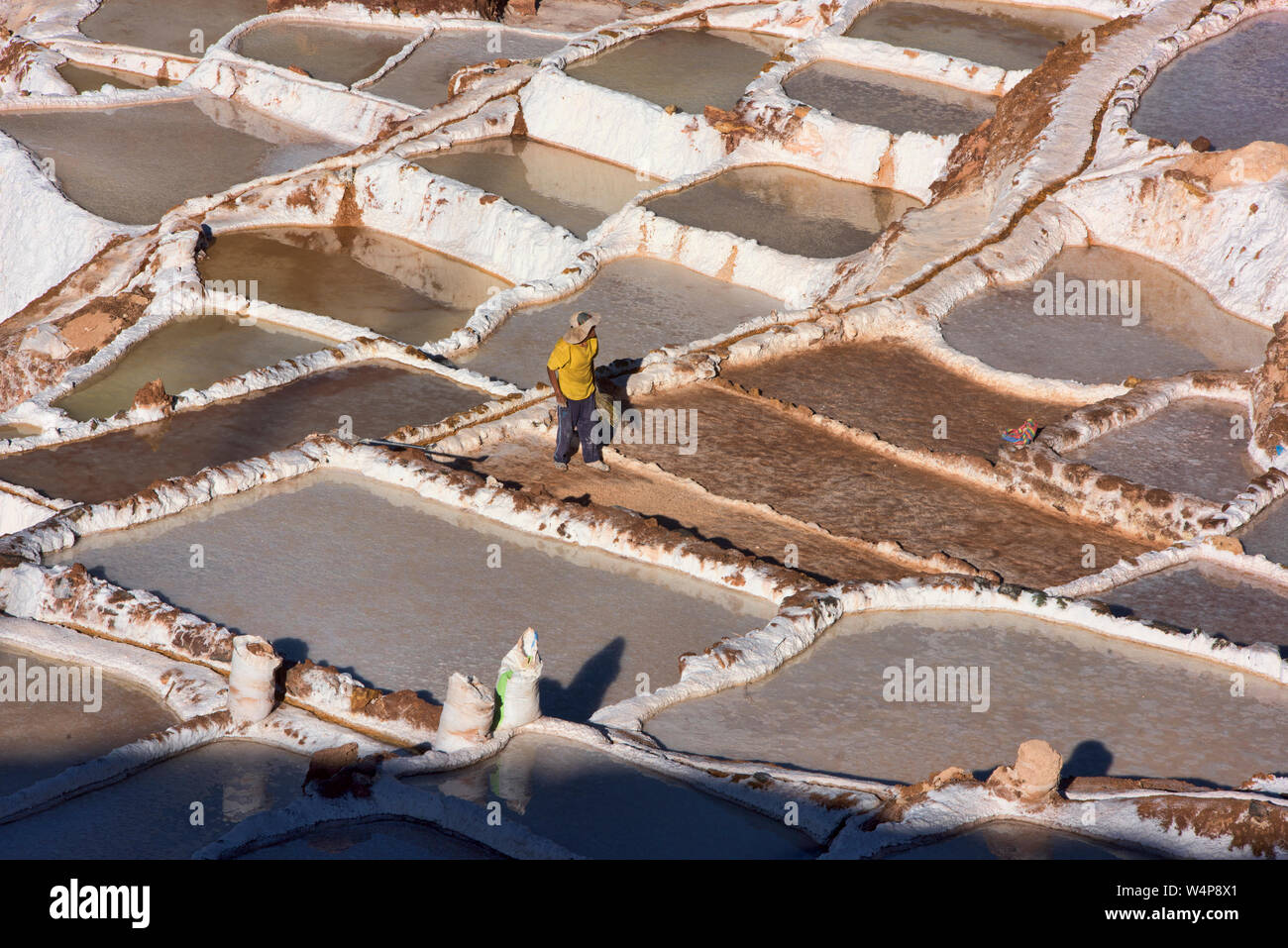Arbeitnehmer durch die Salinen von Maras, das Heilige Tal, Peru umgeben Stockfoto