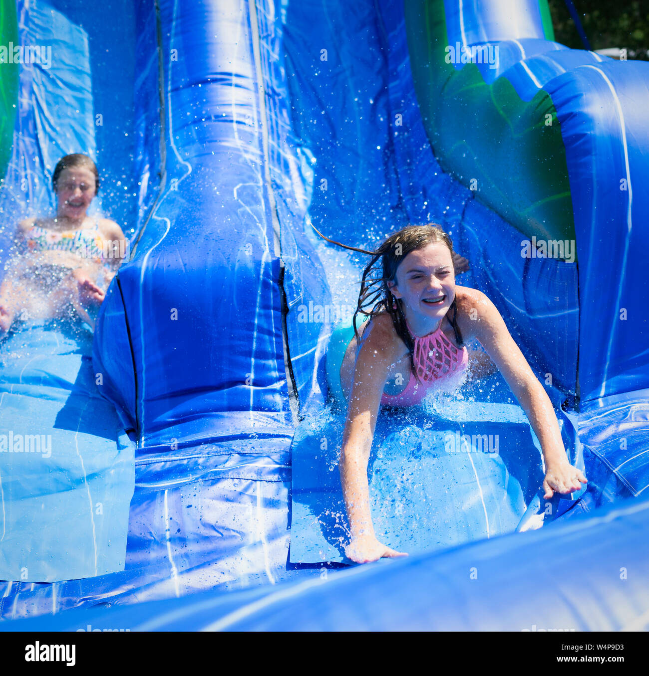 Der Blick auf das Gesicht sagt alles wie Kinder kommen von der Wasserrutsche aus an einem heissen Sommertag in Alabama zu kühlen. Stockfoto