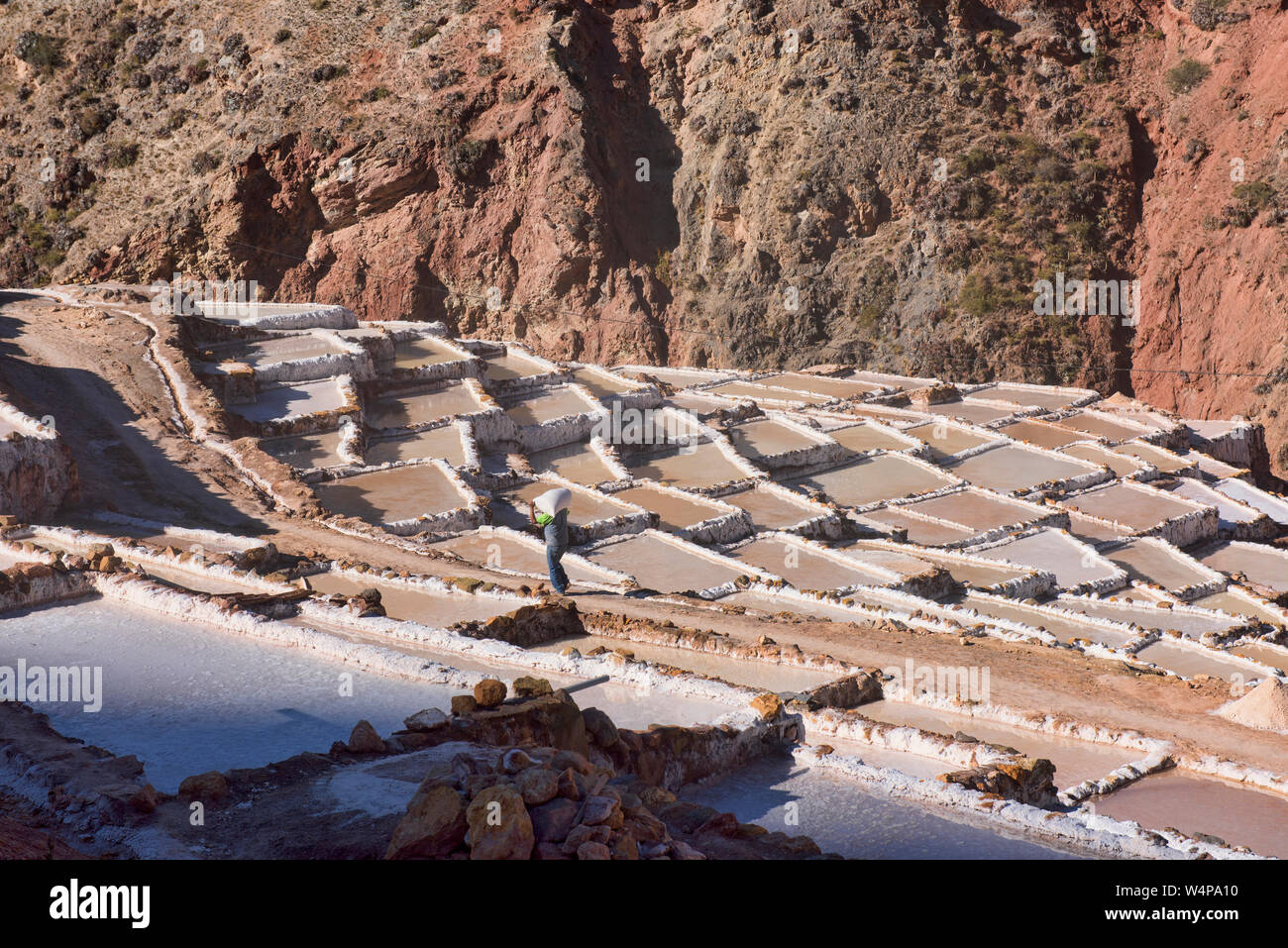 Arbeitnehmer durch die Salinen von Maras, das Heilige Tal, Peru umgeben Stockfoto