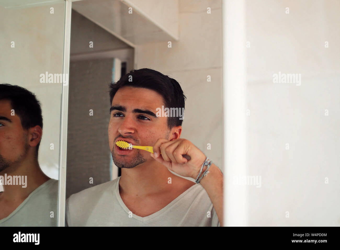 Mann Gekleidet in weiße seine Zähne putzen. Stockfoto