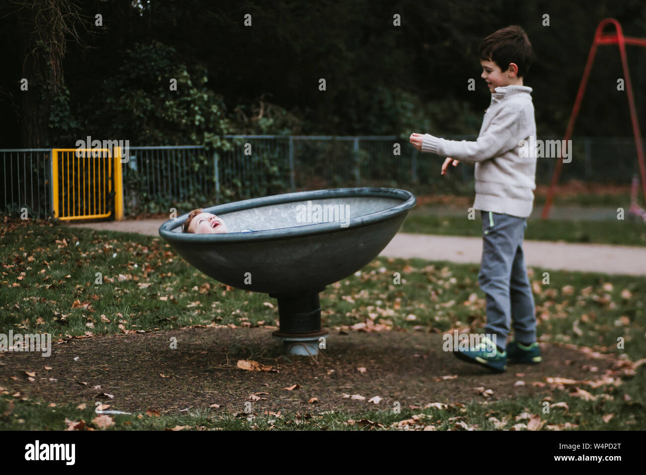 Brüder spielen mit Spinning Schüssel am Spielplatz Stockfoto