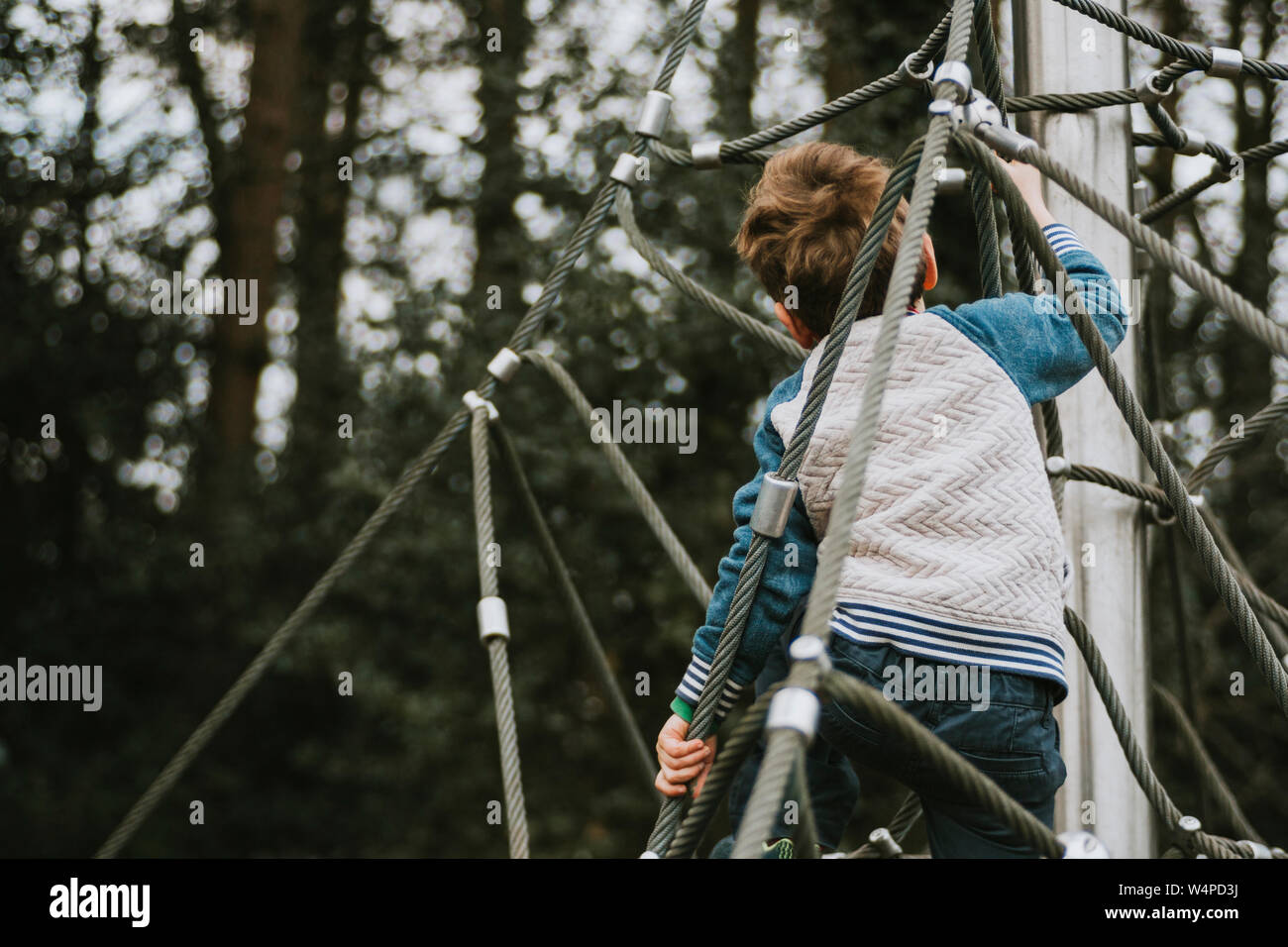 Ansicht der Rückseite des jungen Klettern Klettergerüst Stockfoto