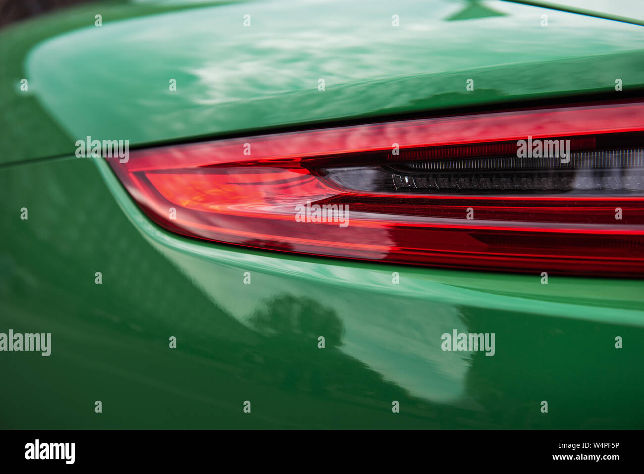Zurück von einem luxuriösen grünen Sportwagen. Nahaufnahme eines modernen roter Hintergrundbeleuchtung. Schöne Karosserie. Stockfoto