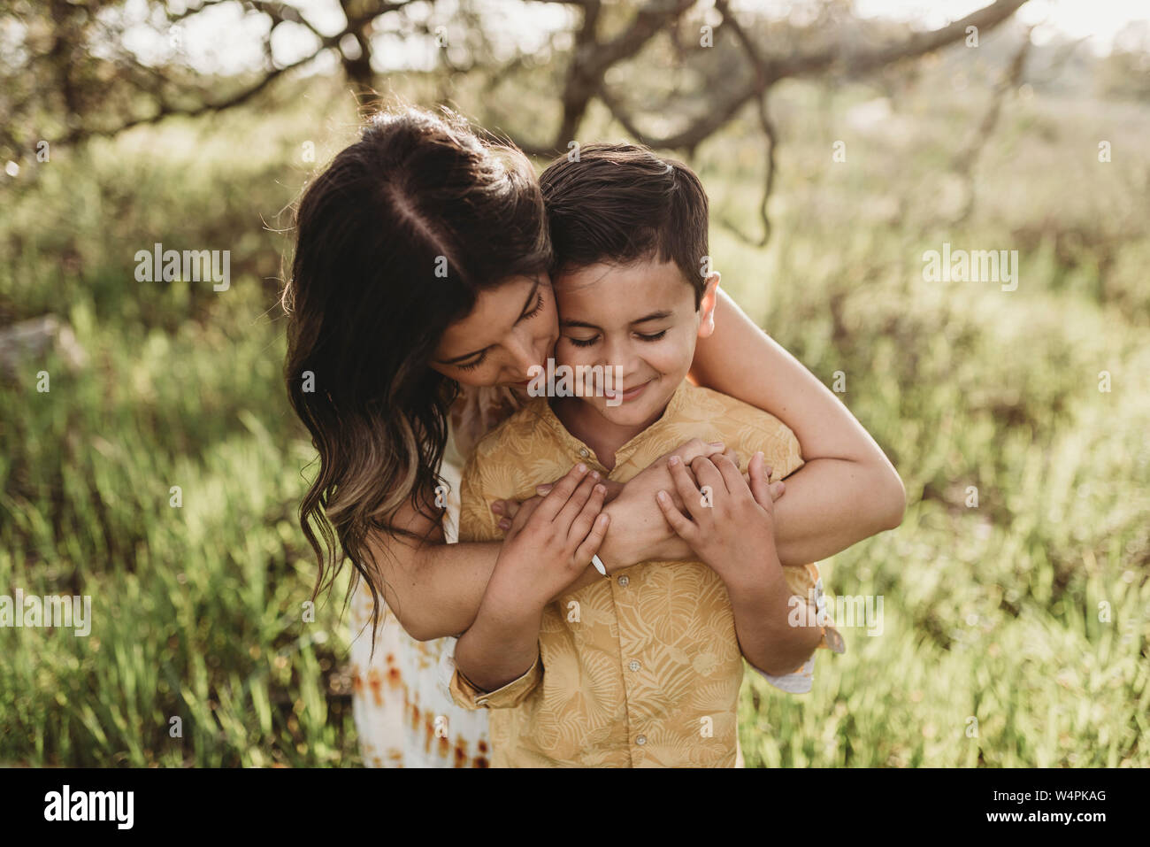 Nahaufnahme der Sohn umarmt von Mutter beim Schließen der Augen Stockfoto