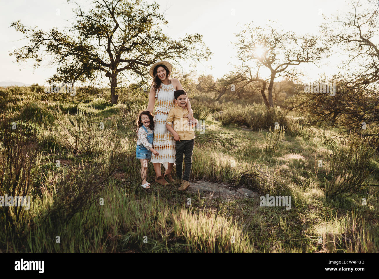 Porträt der schönen Mutter und Kinder im sonnigen Bereich Stockfoto