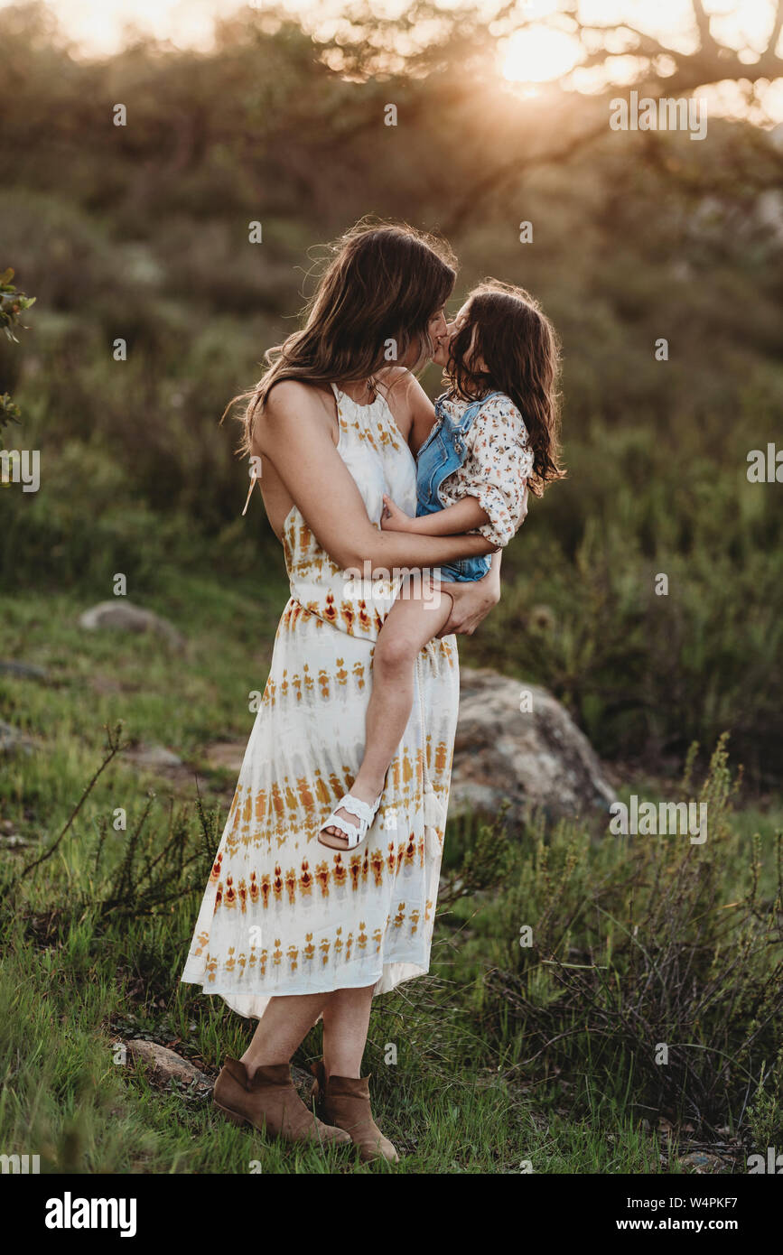 In voller Länge ansehen von Mutter und Tochter küssen im sonnigen Bereich Stockfoto