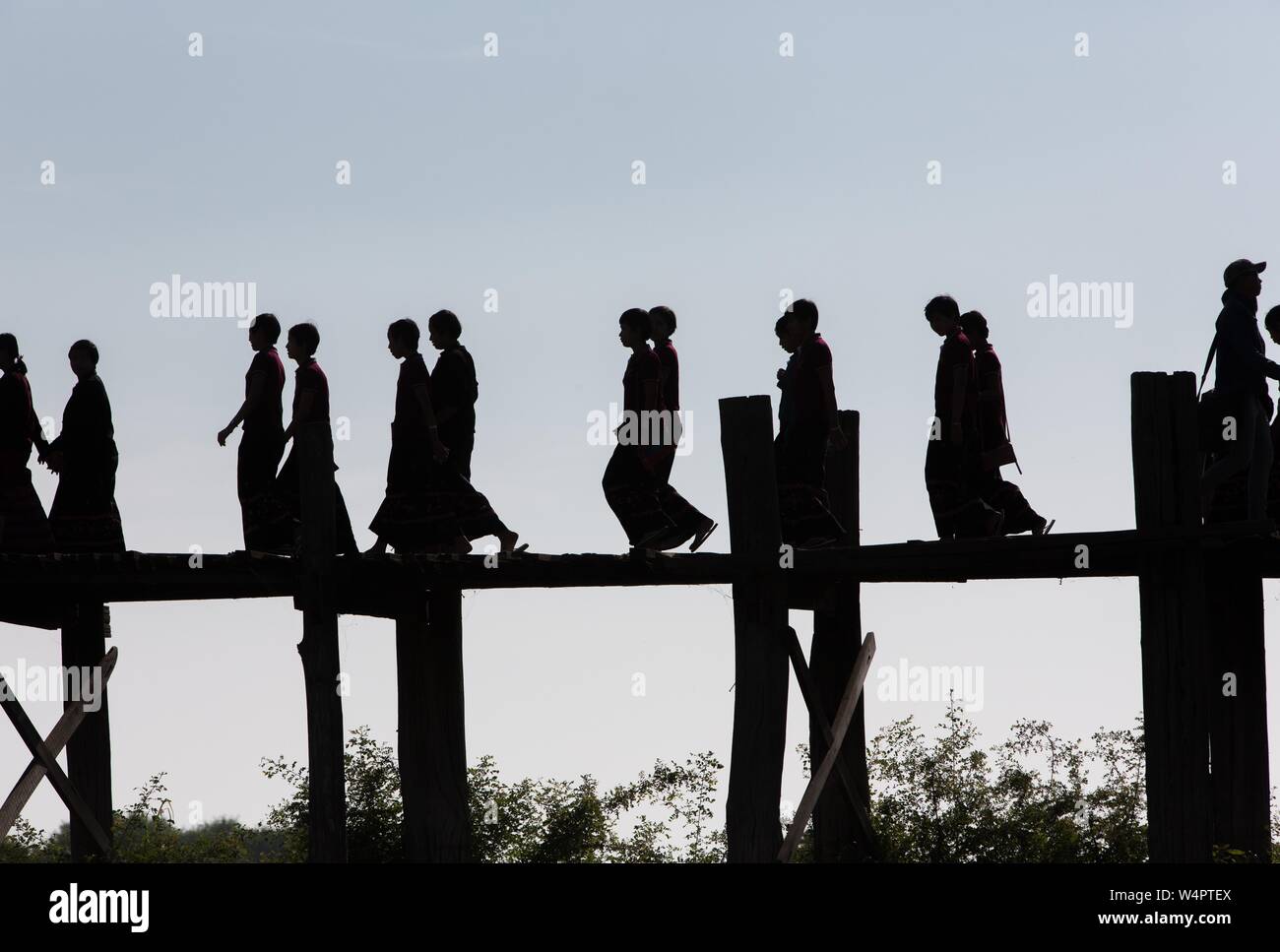 Silhouette der jungen Buddhistischen Novizen auf der U-Bein Brücke am See Taungthaman, Myanmar Stockfoto