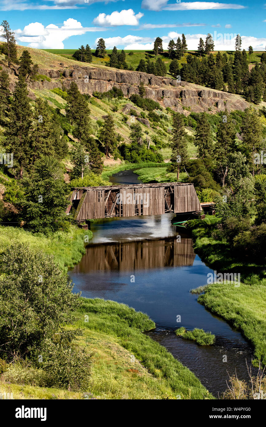 Reflexion eines alten überdachte Brücke über einen kleinen Fluss. Stockfoto
