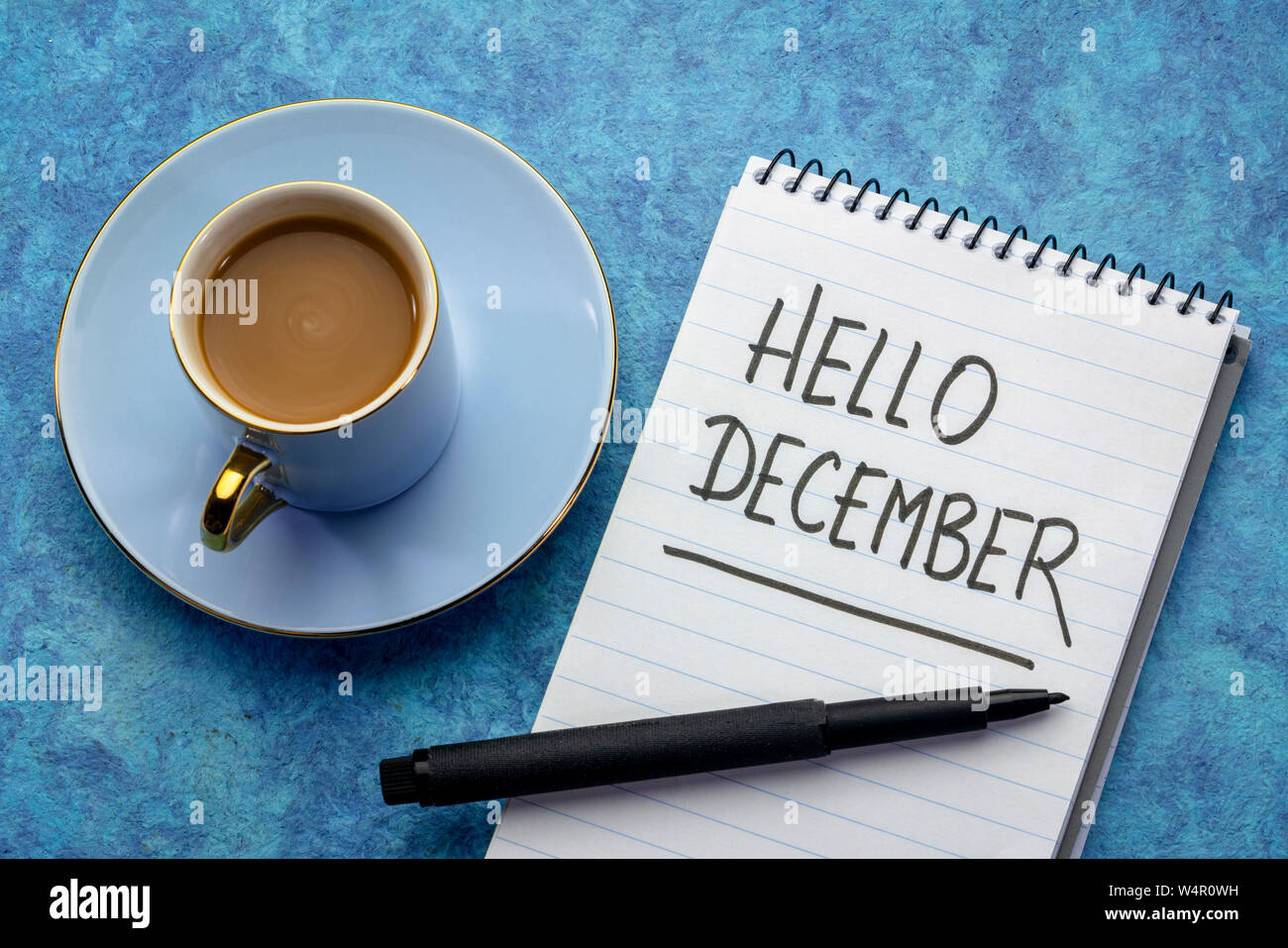 Hallo Dezember - Handschrift in einem Notebook mit einer Tasse Kaffee Stockfoto