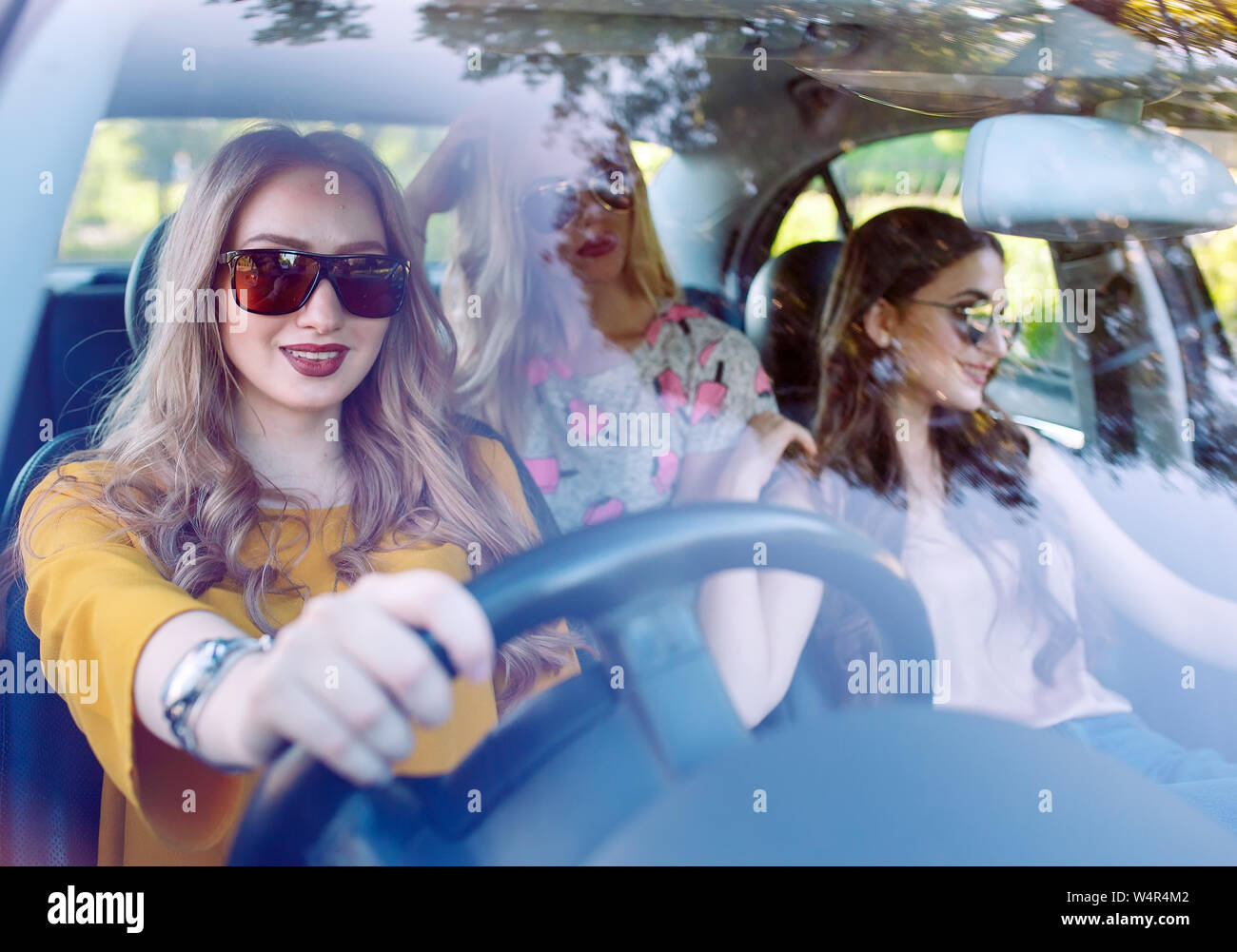 Drei junge Freundinnen in einem Auto unterwegs. Stockfoto