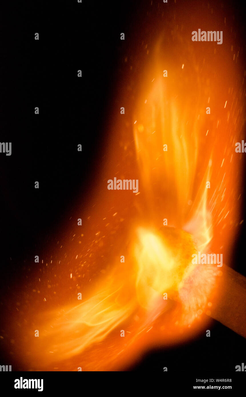 Entzündung von Streichholz mit Flammen vor dunklem Hintergrund, Stillleben Stockfoto