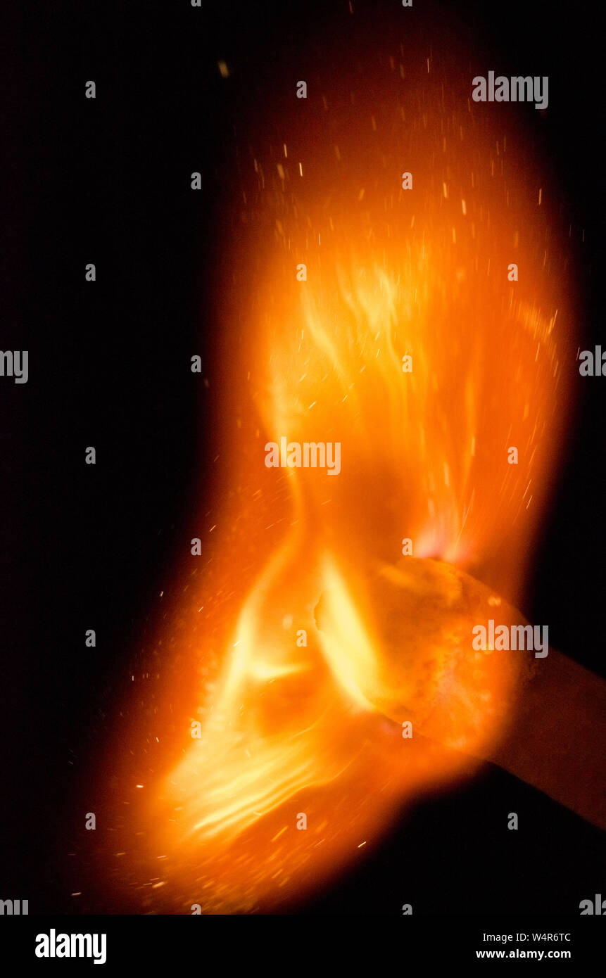 Entzündung von Streichholz mit Flammen vor dunklem Hintergrund, Stillleben Stockfoto