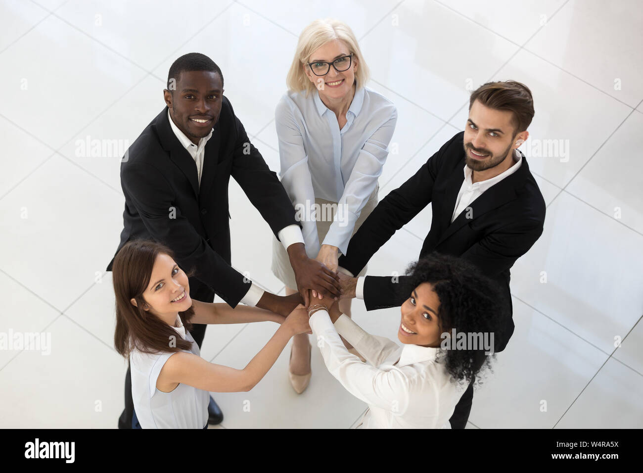 Lächelnd team Mitarbeiter Ablagestapel der Hände der Ansicht von oben Stockfoto