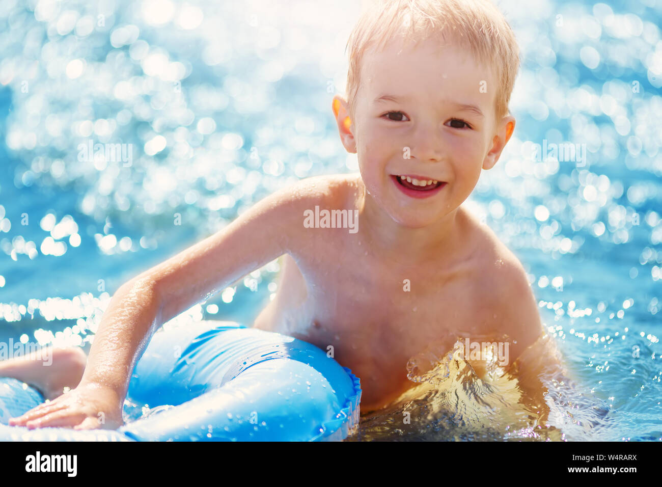 Drei Jahre alten Jungen spielen am Strand mit Schwimmen Ring Stockfoto