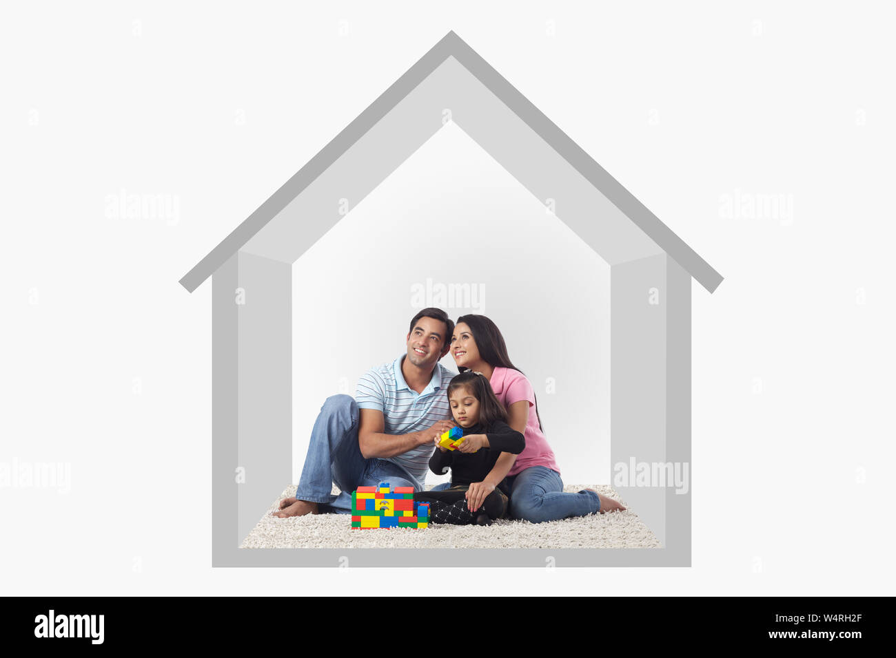 Familie sitzt auf dem Teppich in einem Haus Stockfoto