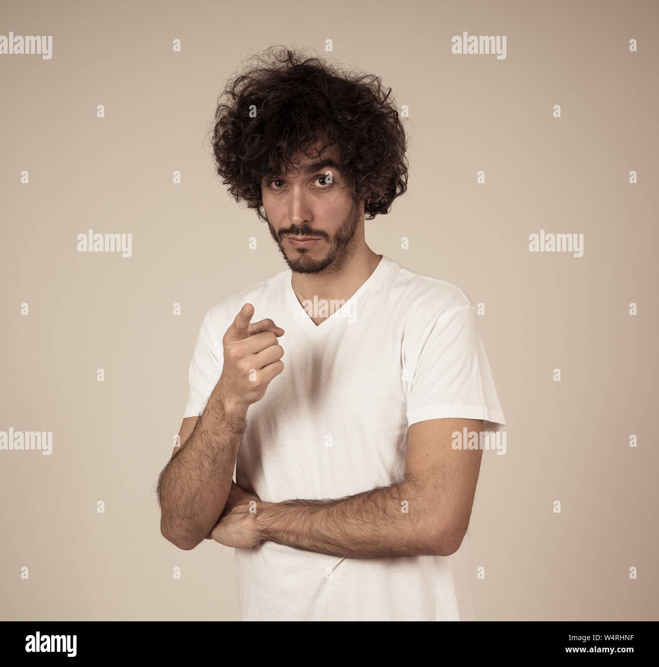 Studio geschossen von fröhlicher junger tausendjährigen Männlich mit Bär und großes Haar lächelnd und machen lustige und freundliche Gesten. Auf neutralem Hintergrund isoliert. Stockfoto