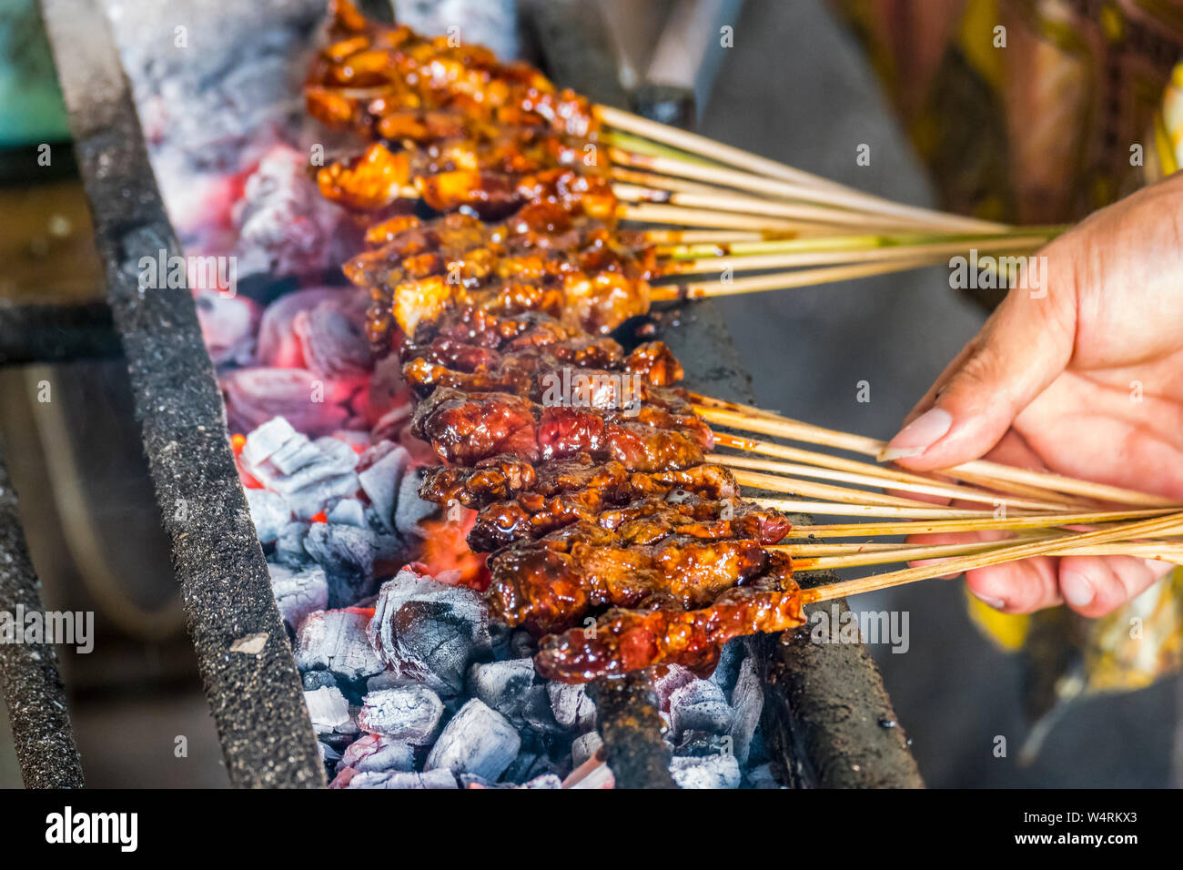 Hand der Person kochen Lamm shashliks über Grill, Ubud, Bali, Indonesien Stockfoto