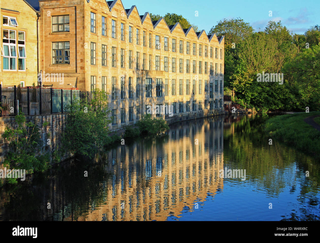 Häuser, die von der Seite des Leeds und Liverpool Canal dargestellt im Abendlicht. Dieses Gebäude war einer der Brierfield Mühlen Stockfoto