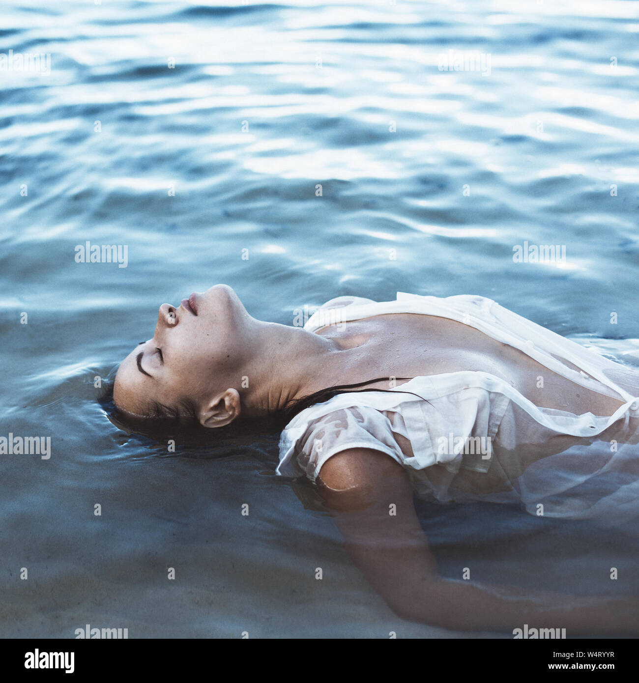 Frau liegt auf dem Rücken im Meer, Seychellen Stockfoto