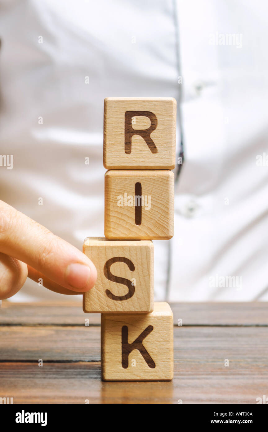 Man entfernt die Bausteine mit dem Wort Risiko. Das Konzept der Verringerung der möglichen Risiken. Versicherung, Stabilität unterstützen. Rechtlicher Schutz der geschäftlichen Interessen. F Stockfoto