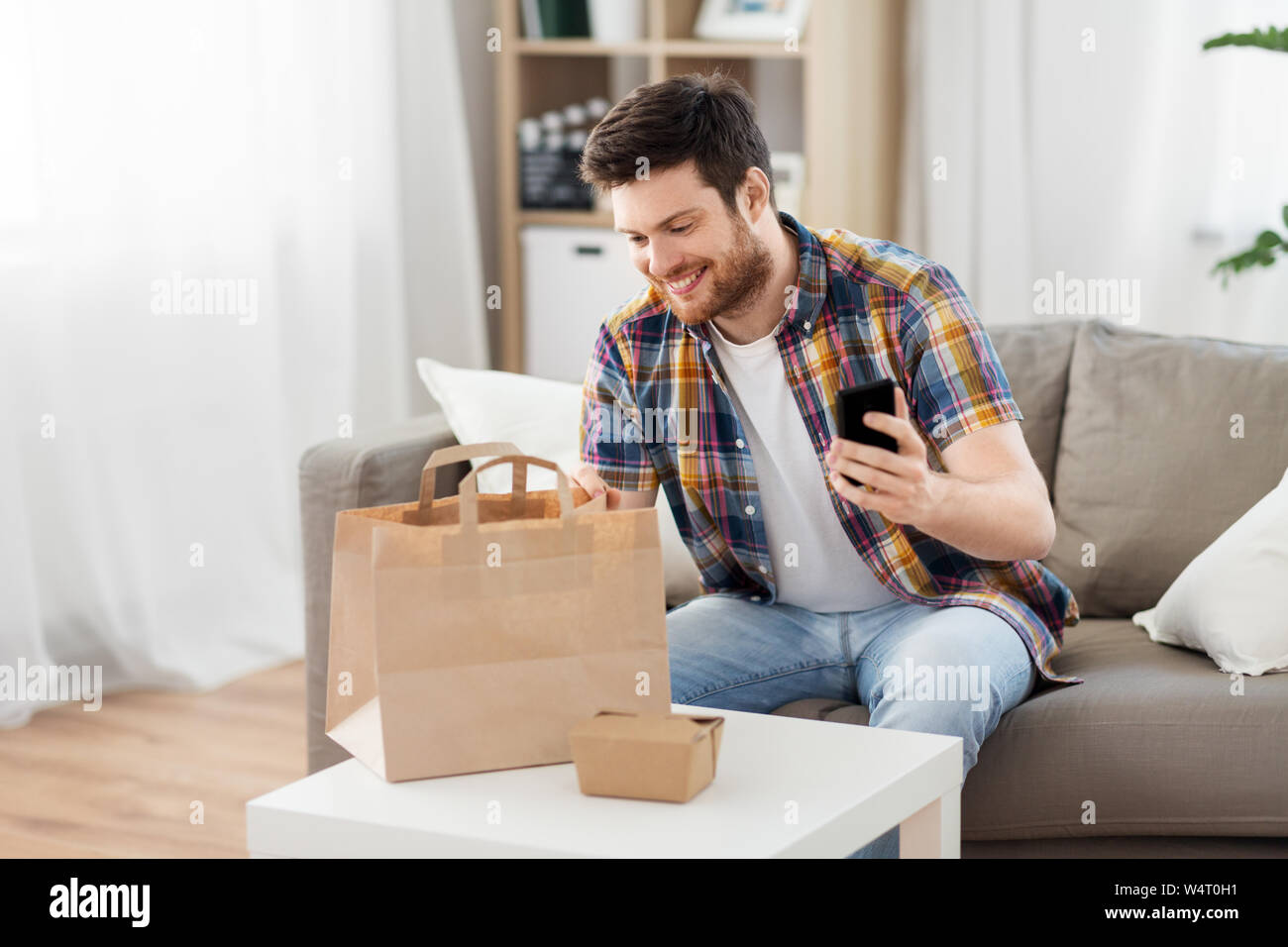 Man Kontrolle Essen zum Mitnehmen bestellen zu Hause Stockfoto