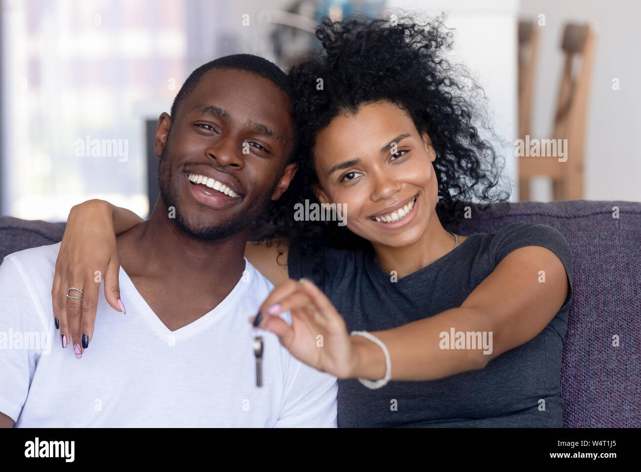 Afrikanische Paar sitzt auf der Couch holding Keys von neues Haus Stockfoto