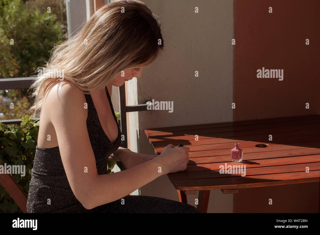 Frau sitzt an einem Tisch setzen auf Nagellack Stockfoto