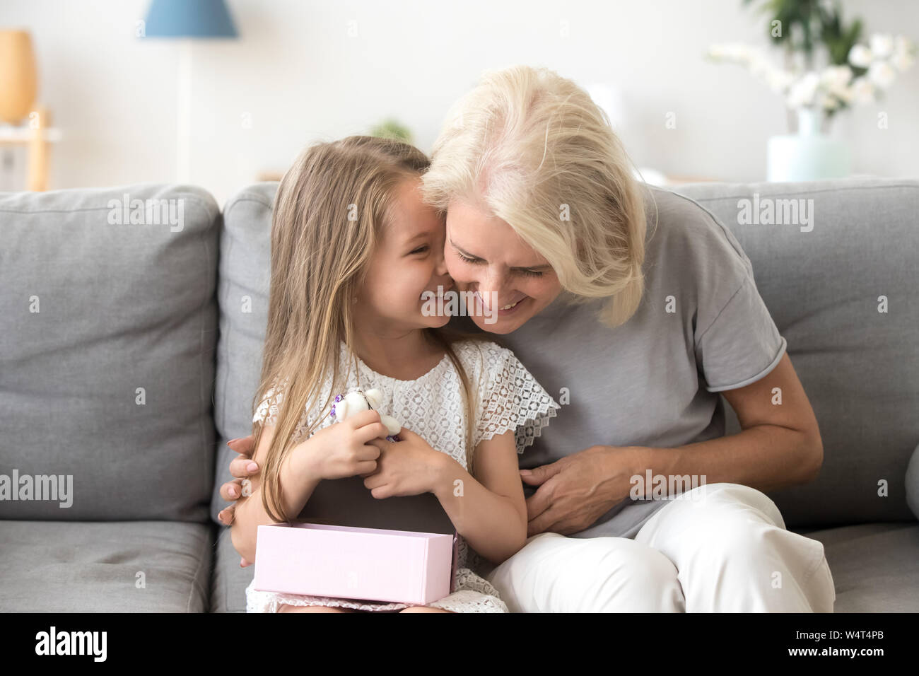 Freundliche Oma und Enkel gemeinsam lachen auf der Couch sitzen Stockfoto