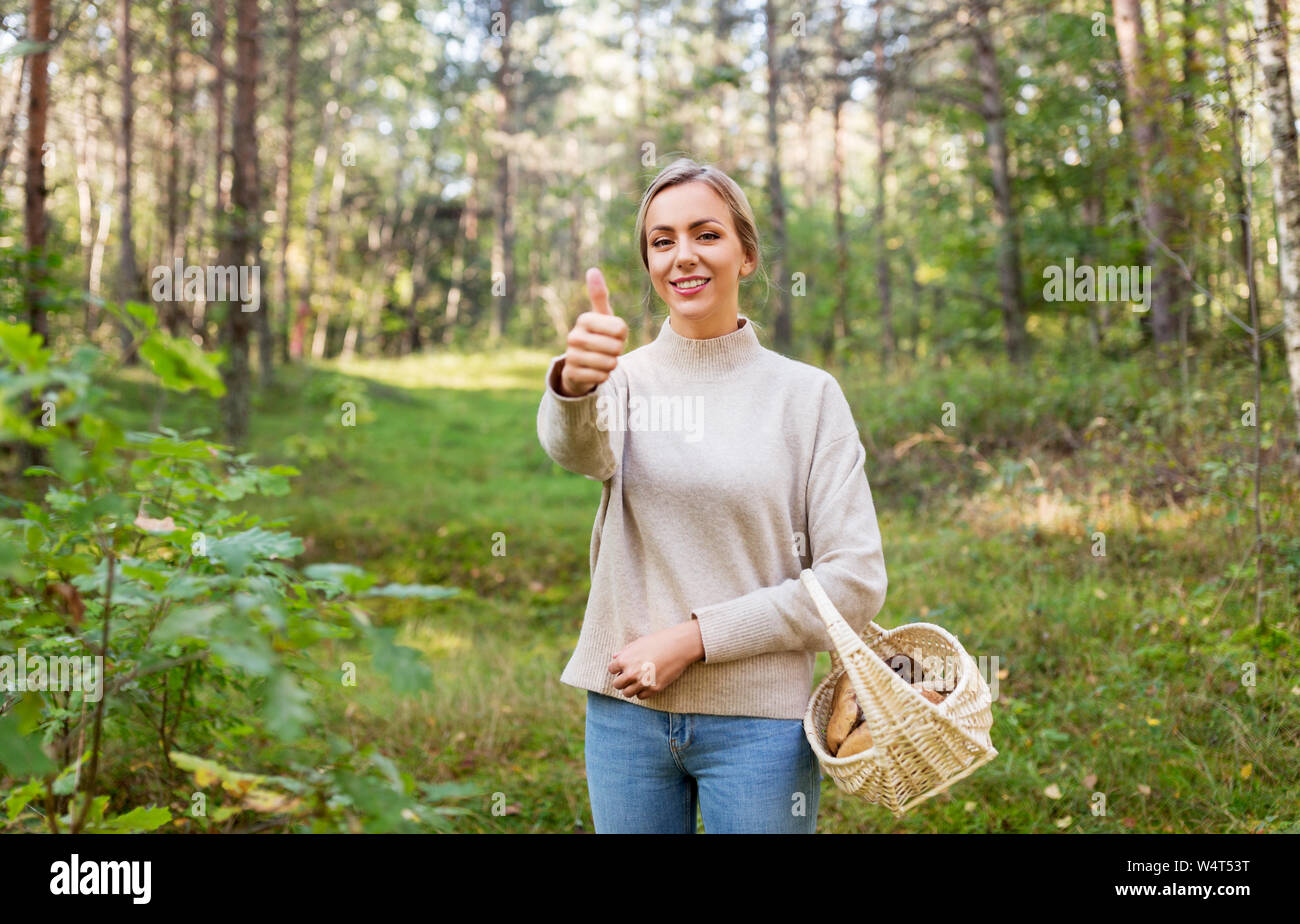 Frau mit Korb mit Pilzen im Wald Stockfoto