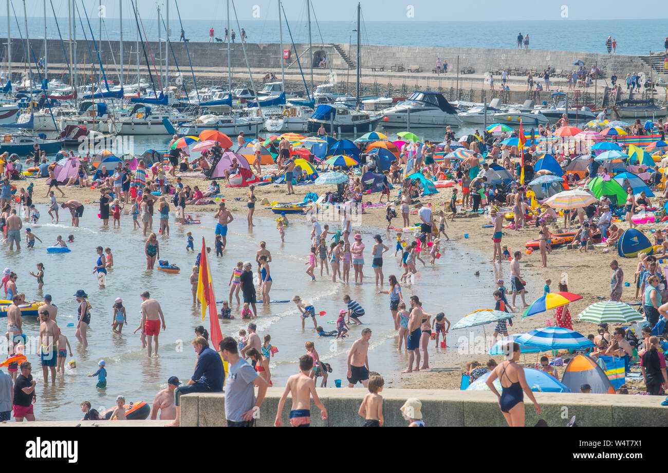 Lyme Regis, Dorset, Großbritannien. 25. Juli 2019. UK Wetter: Massen von sunskeekers Erfrieren in rekordverdächtige Wärme am Strand an der Küste von Lyme Regis auf was erwartet wird, der heisseste Tag werden im Vereinigten Königreich überhaupt. Britische Urlauber erfrieren in Sizzling Hot Sunshine auf gepackten Strand der Stadt die Temperaturen steigen auf 40 Grad. Die Kühlung ist willkommene Abwechslung von der sengenden Hitze als Juli Hitzewelle weiter. Credit: Celia McMahon/Alamy Leben Nachrichten. Stockfoto