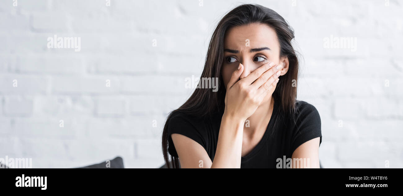 Angst Frau mit der Hand auf das Gesicht und Wegsehen, während von Panikattacken leiden zu Hause Stockfoto
