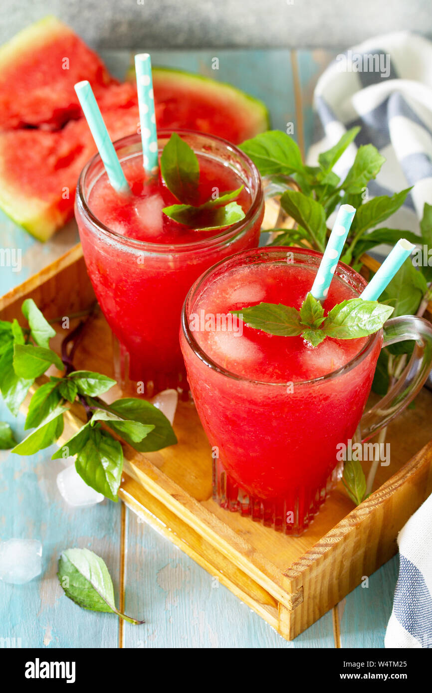 Kalte Wassermelone Smoothie. Sommer Wassermelonen trinken in Gläsern und Scheiben Wassermelone auf rustikalen Holztisch. Stockfoto