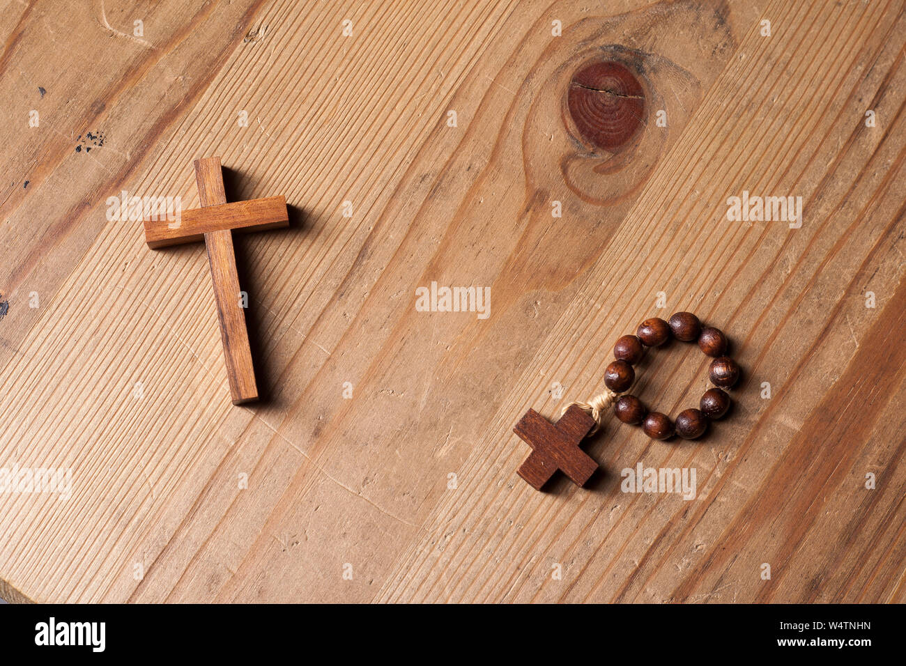 Kreuz und Rosenkranz über Holz Tisch mit Fenster Licht Stockfoto
