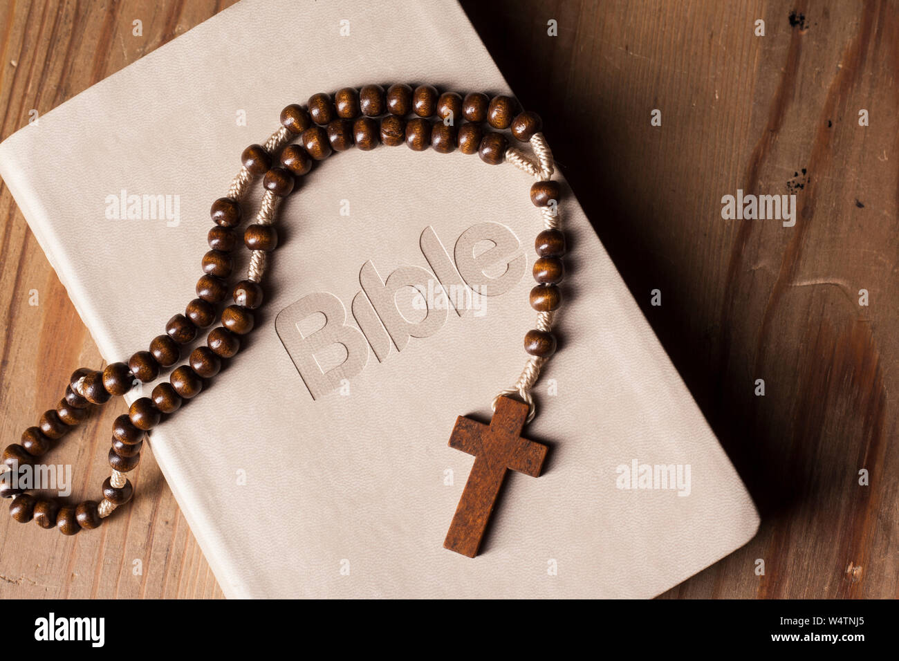Heilige Bibel mit Rosenkranz auf dem Holztisch Stockfoto