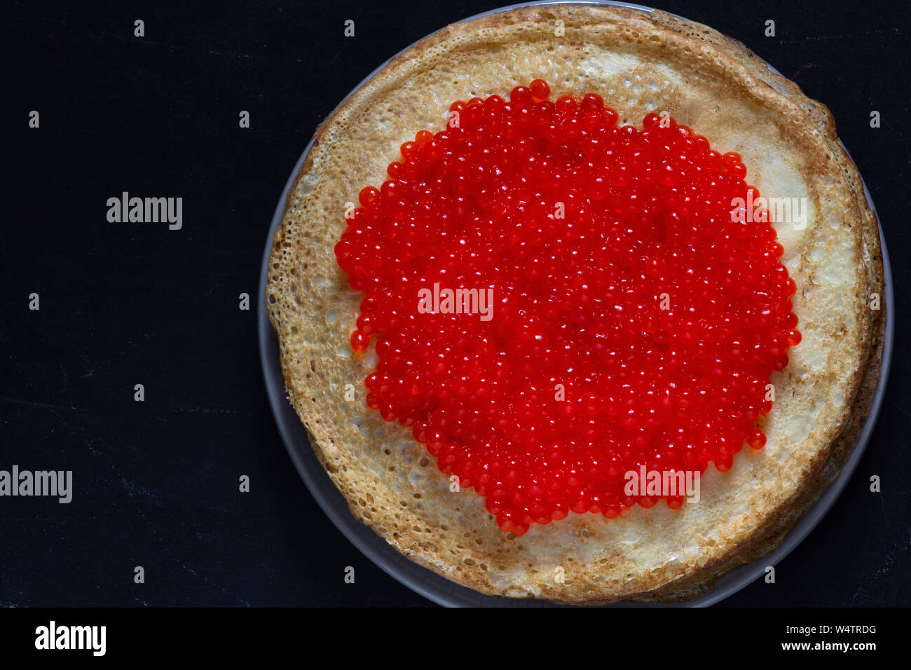 Stapel von porösen Blini mit rotem Kaviar auf der Oberseite Stockfoto