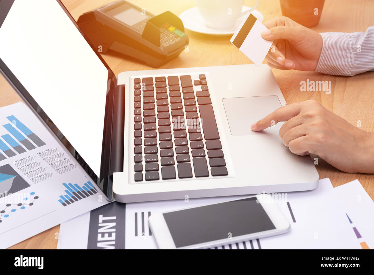 Frau mit Kreditkarte und Kauf online Zahlung per Computer Notebook Laptop mit leeren weißen Bildschirm am Arbeitsplatz Stockfoto