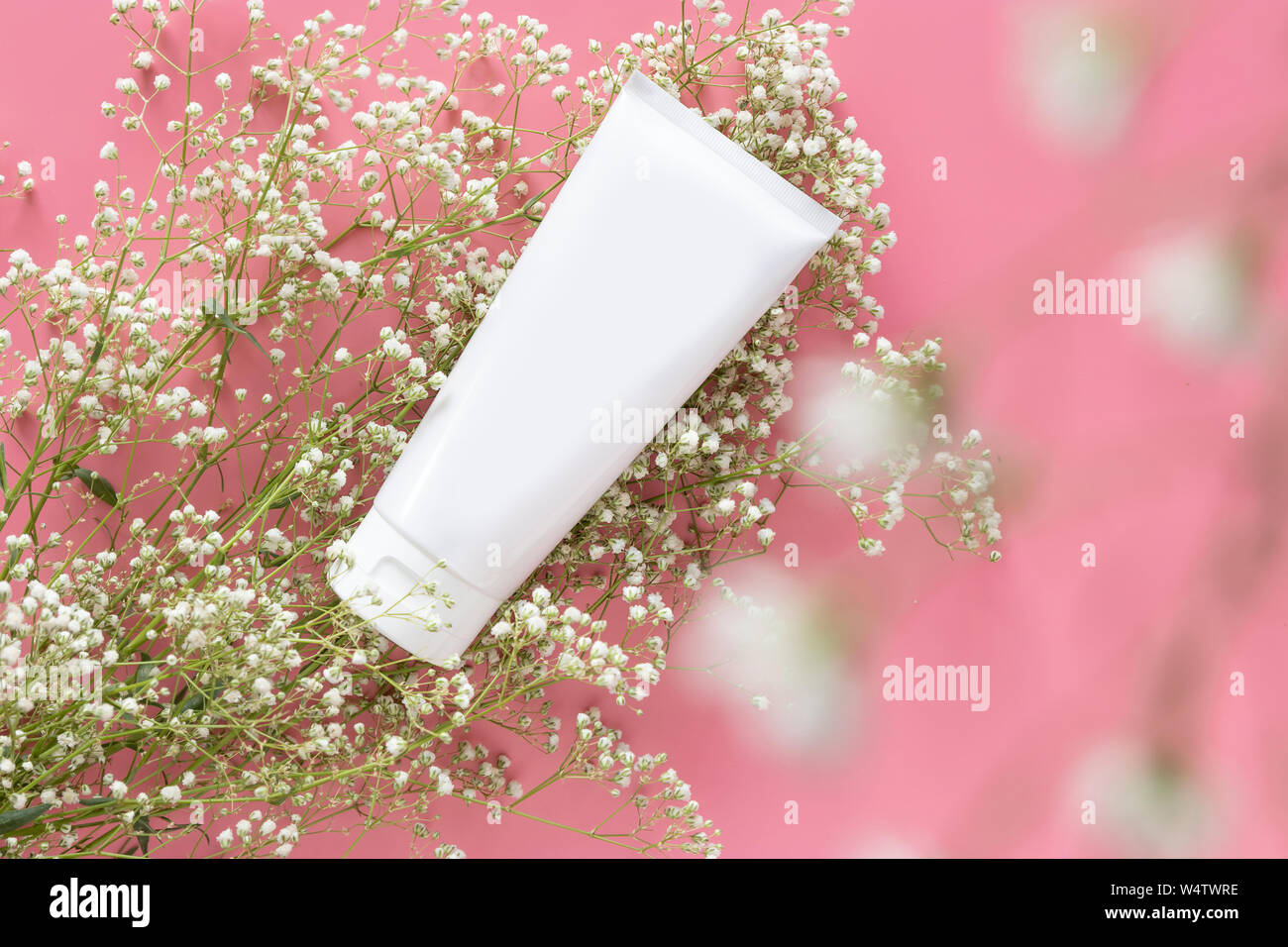 Kosmetischer Natur organische Hautpflege Kosmetik Konzept. Weiße Tube Container mit leeres Etikett für das Branding Verpackung mock up, mit weißen Blumen o Dekorieren Stockfoto